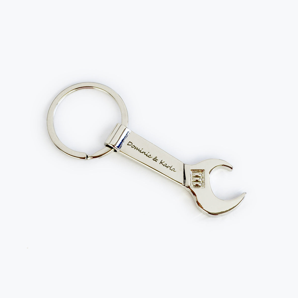 Single silver tone wrench keychain engraved with two names in script font. bottle opener keychain