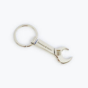 Single silver tone wrench keychain engraved with two names in script font. bottle opener keychain