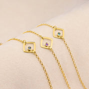 Series of three open square geometric bracelets with kyanite, purple amethyst and blue topaz birthstones. 