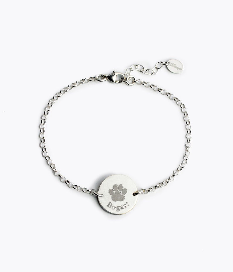 Engrave your fur baby's paw print on this silver anklet disc featuring a stock print and name in typewriter font. 