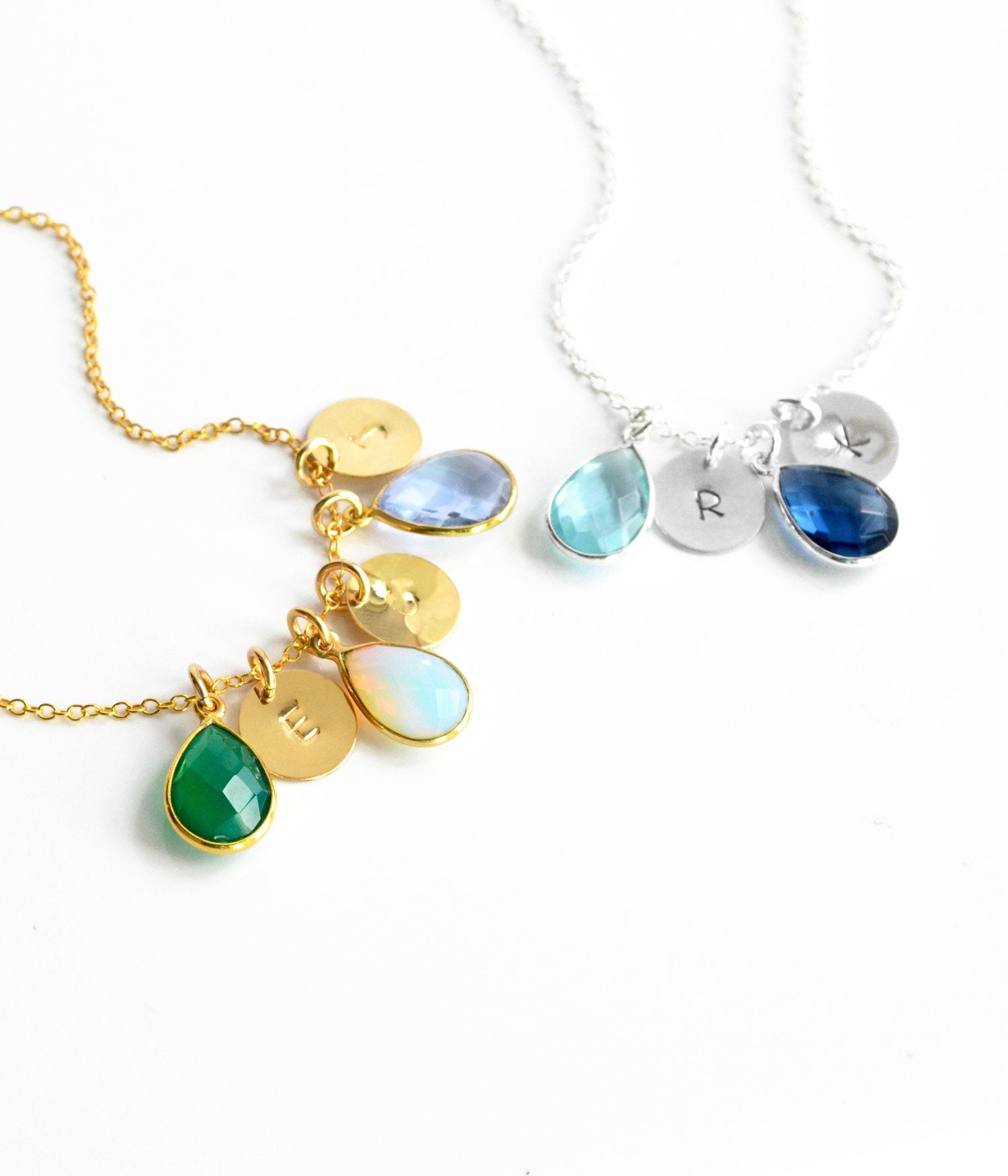 Gold cable chain with three birthstones green onyx, moonstone and alexandrite, sterling silver birthstone necklace with stamped polished disk with blue topaz and kyanite birthstones. 