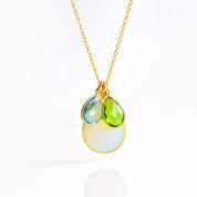 Single gold filled cable chain with mothers moonstone, peridot and sky blue children's birthstones on white background.